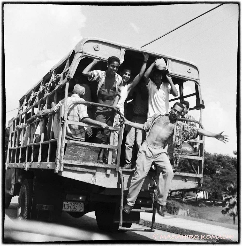 バスから手を振る陽気なキューバ人の写真