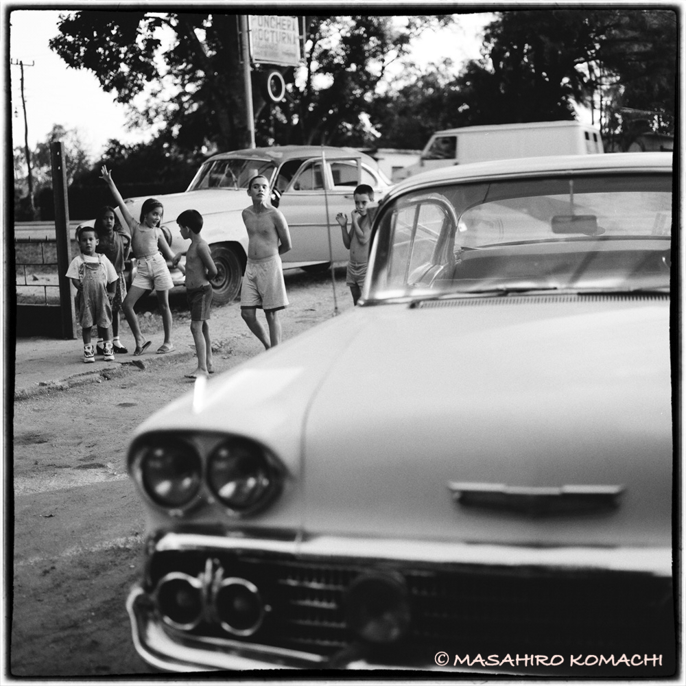 Photo of a boy playing around a Cuban old candy car