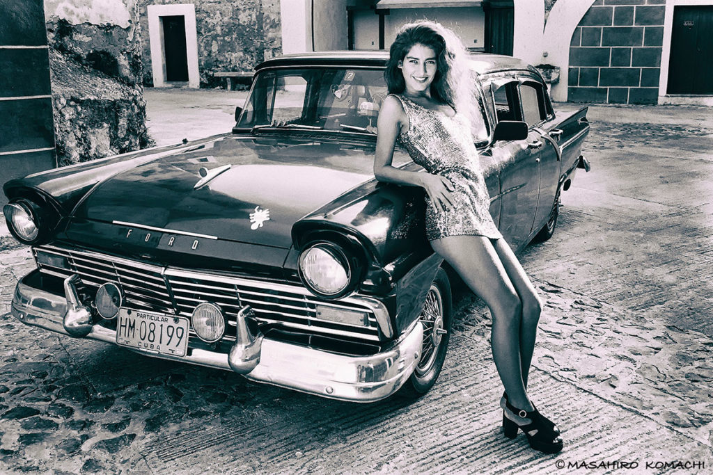 Portrait of old American car and model in Cuba cityscape